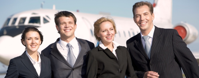 Group of four leaders smiling on the background of the airplane
